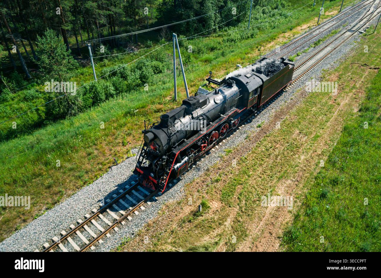 Parallel Train Aerial view captures an old black steam locomotive moving along ...