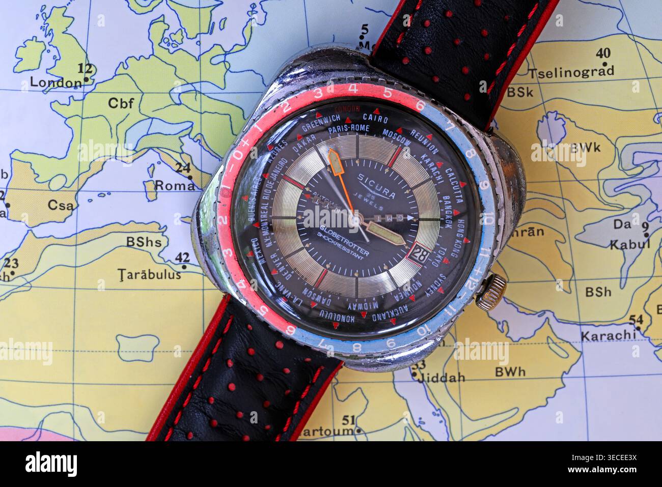 Vintage 1970s Sicura Globetrotter GMT world time watch with Pepsi bezel, Europe, GMT and New York time, photographed on a map. Stock Photo