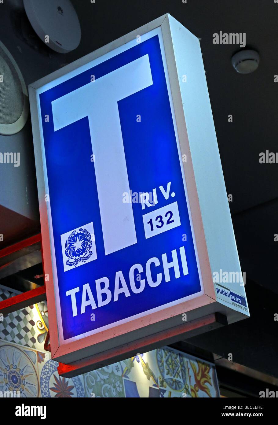 Blue and white Tabacchi sign outside a licensed tobacconist in Sicily, Italy, displaying retail concession number 132. Stock Photo