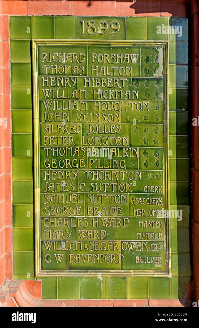 Victorian green glazed tile memorial naming officials linked to Warrington Workhouse Infirmary, later the NHS hospital Kendrick Wing. Stock Photo