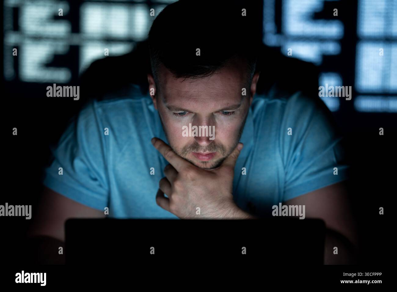 Hacker types code with concentration. Hacker analyzes network security system. Hacker monitors online data transmission. Hacker executes phishing Stock Photo