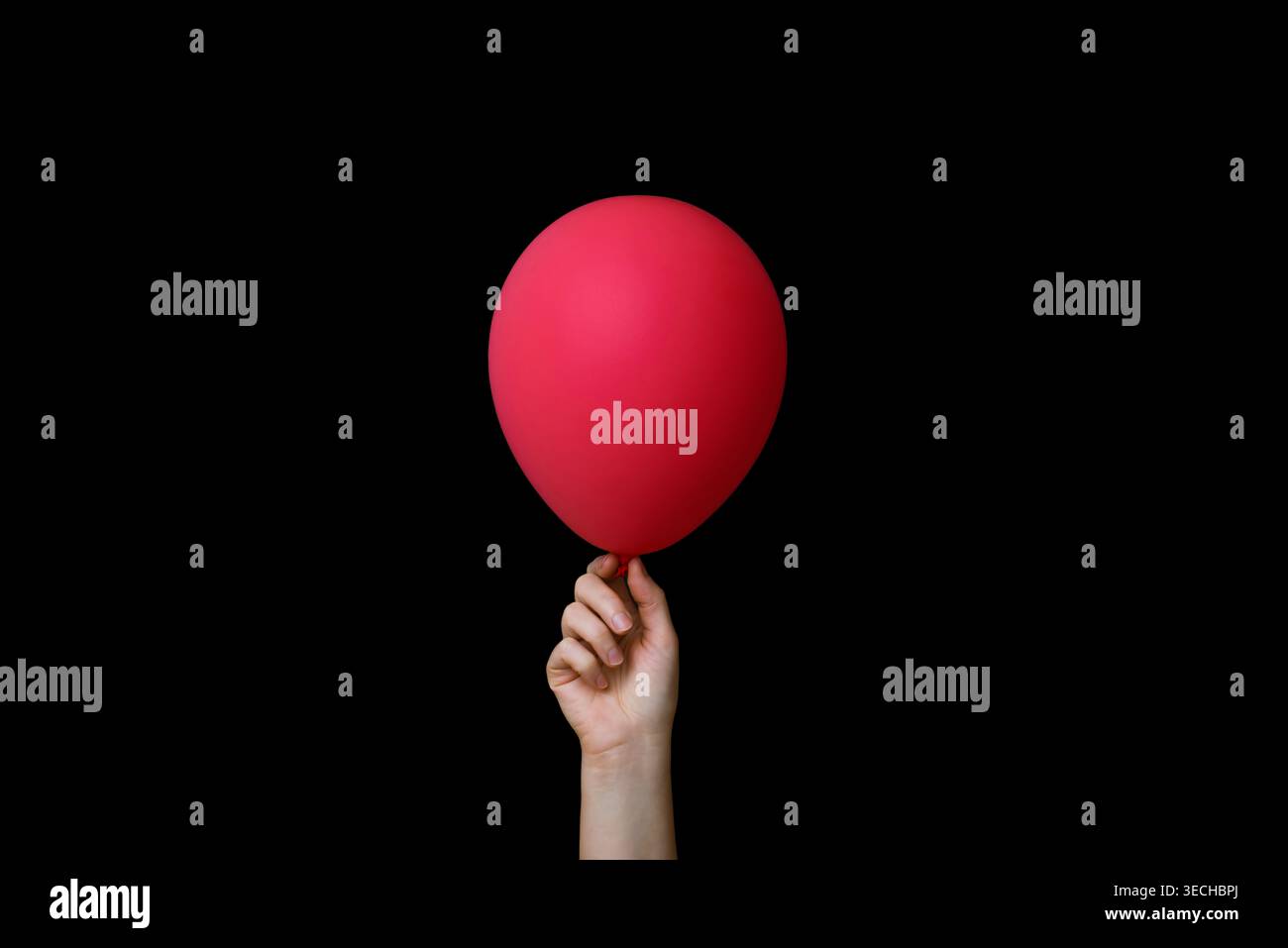 Hand Holding Red Balloon on Black Background Stock Photo