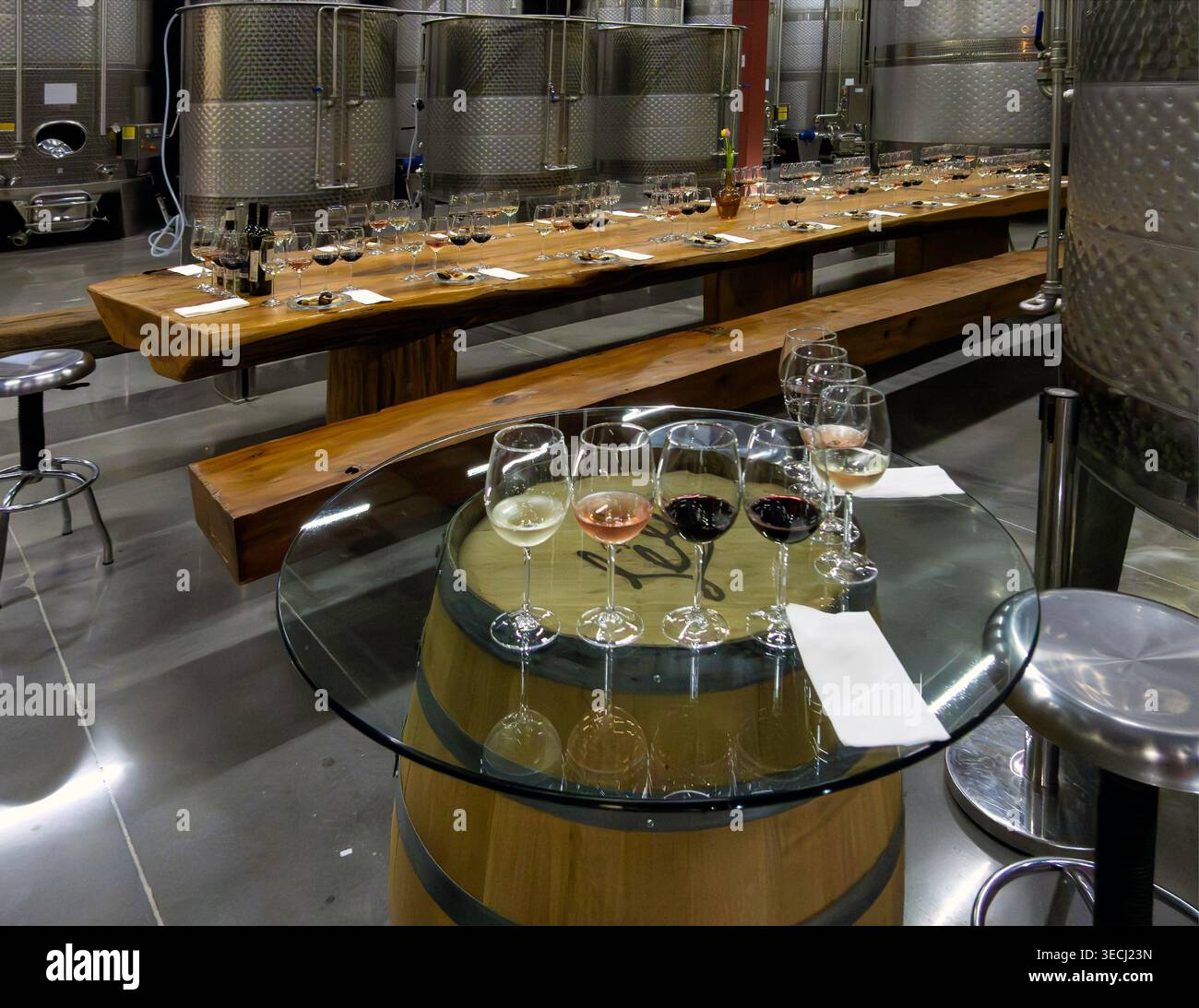Tables laid out in preparation for a wine tasting event in the cellar of a winery Stock Photo