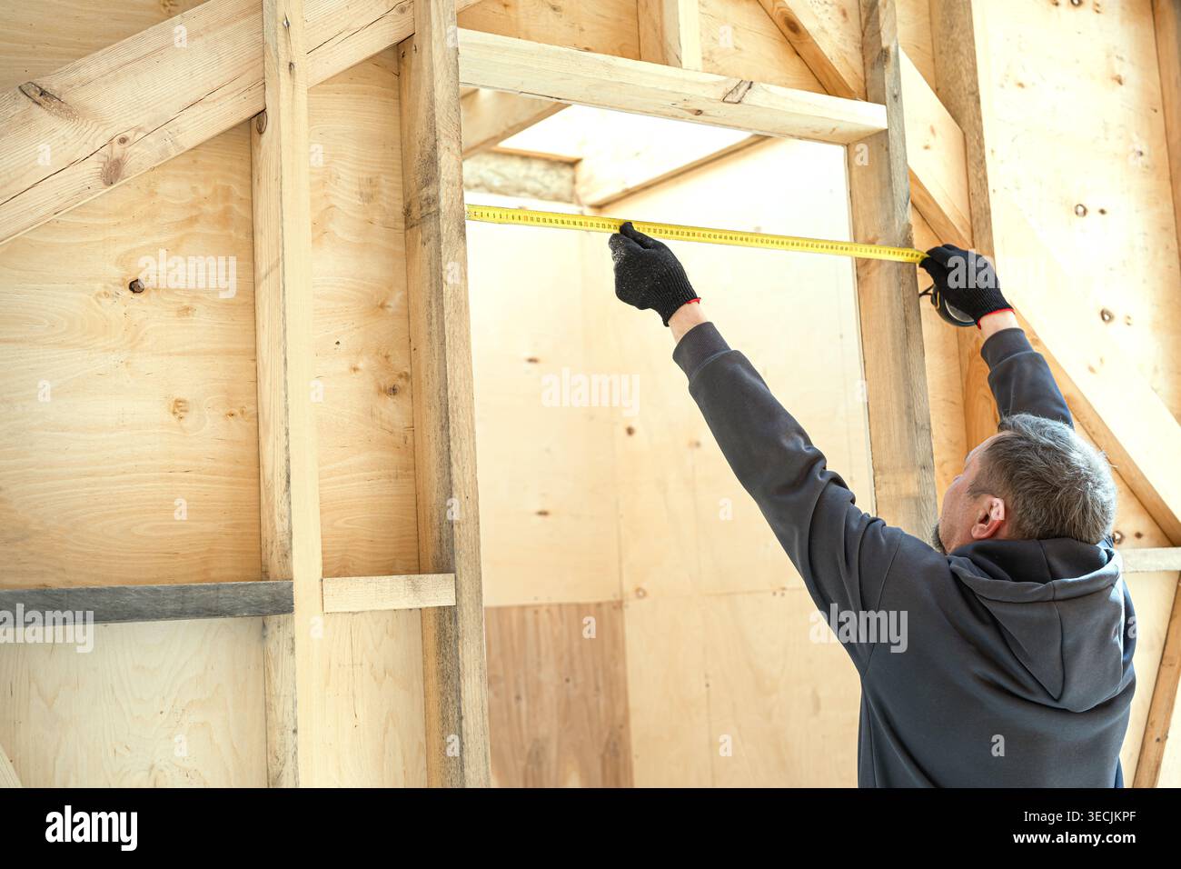 Carpenter man measuring a door frame in new house under construction ...