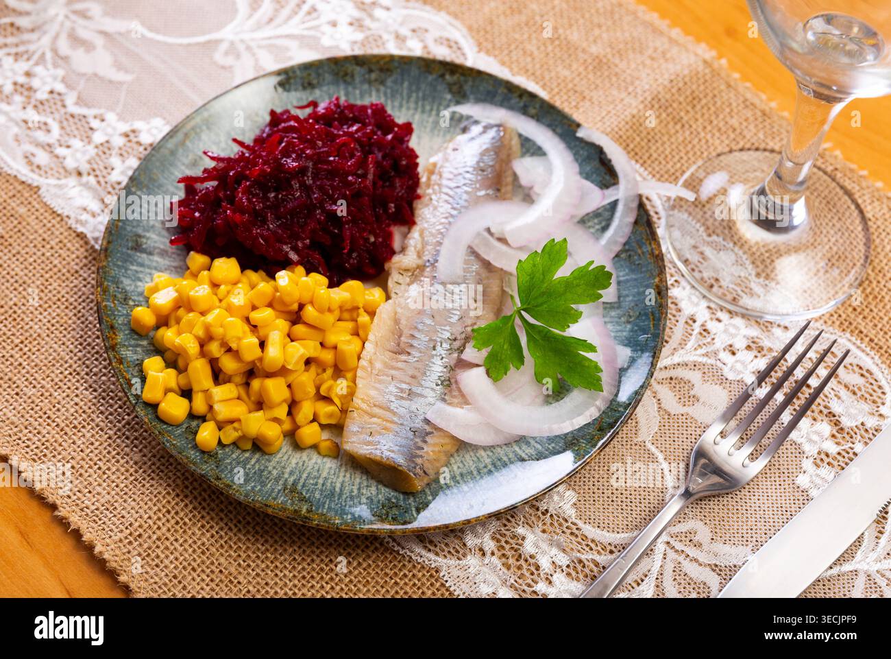 Herring served on plate with grated beetroot and corn Stock Photo
