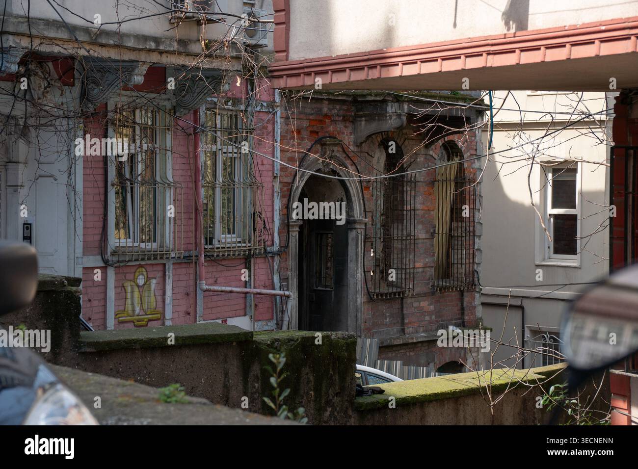 Istanbul, Turkey - April 1, 2026: Old residential buildings in Balat with worn facades, arched windows, metal bars with layered structures Stock Photo