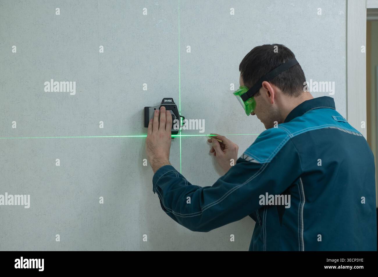 A man measures distance with a laser level. Stock Photo