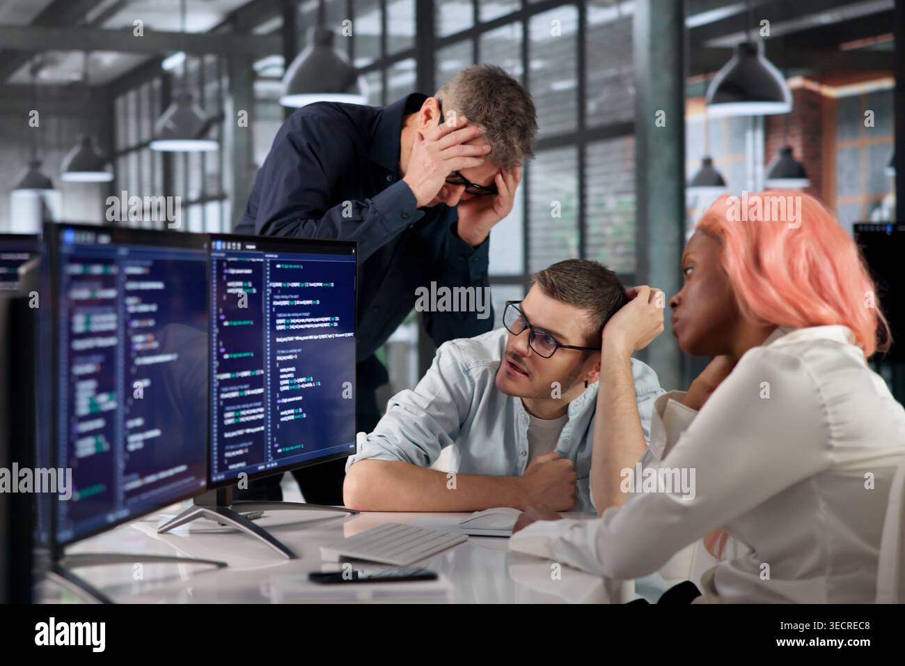 Software Engineer Struggles With Broken Code While Stressed At Desk. Stock Photo