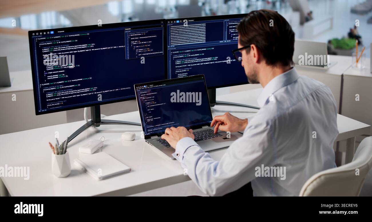 Man Focused On Coding Laptop, Developing Web Project In Modern Office. Stock Photo