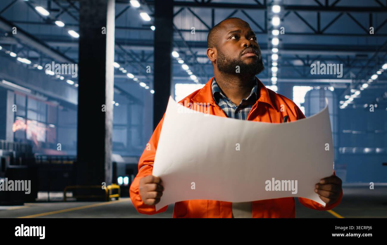 Heavy Workforce Employee walking in a facility with steel production plans in heavy ...