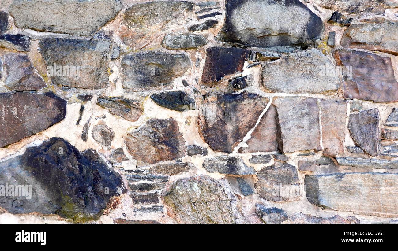 Exterior stone brick wall angled shape medieval Dark grey texture and background Stock Photo