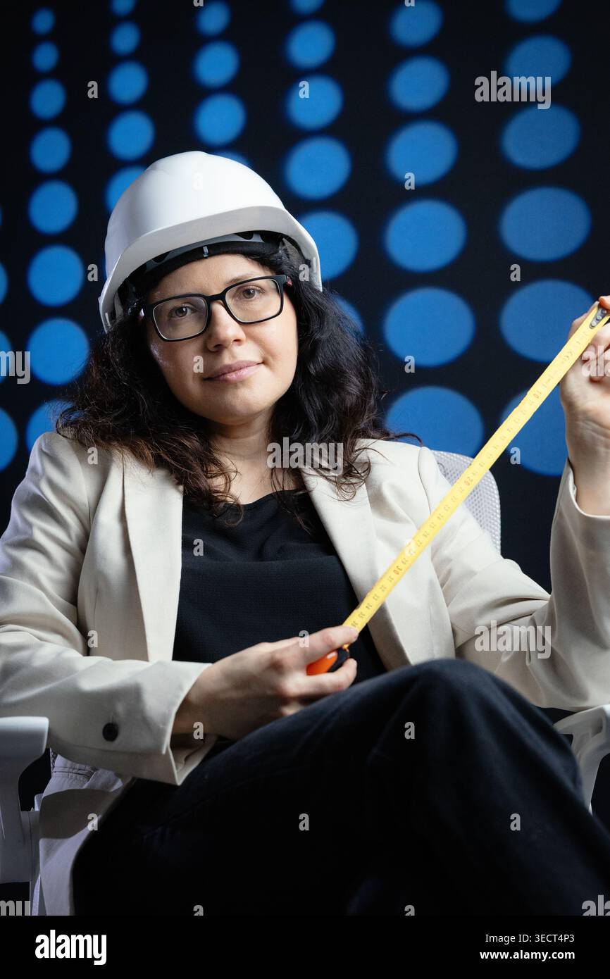 Woman engineer holding measuring tape developing project Stock Photo