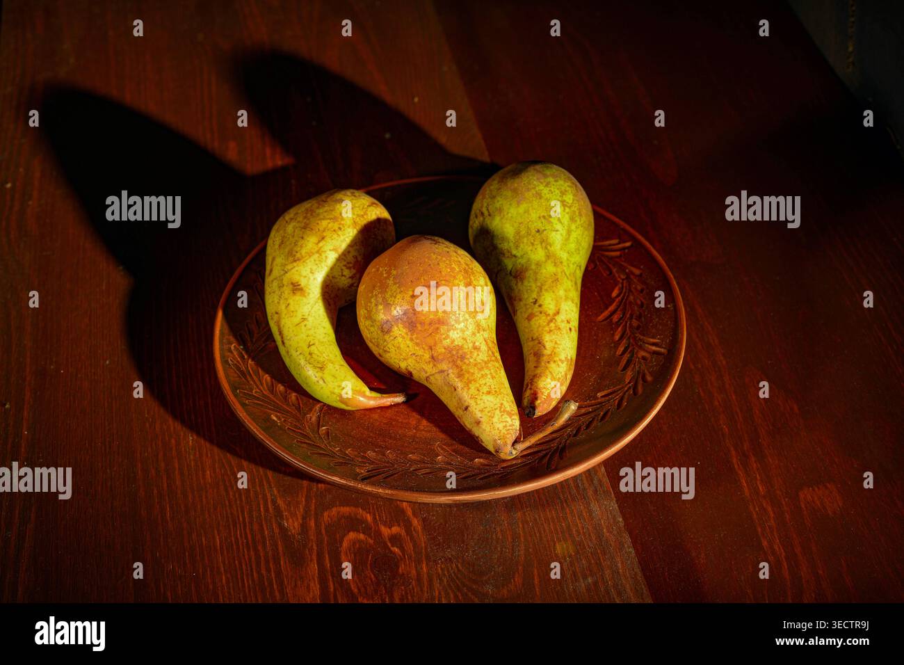 Still life with pears arranged in a ceramic plate Stock Photo