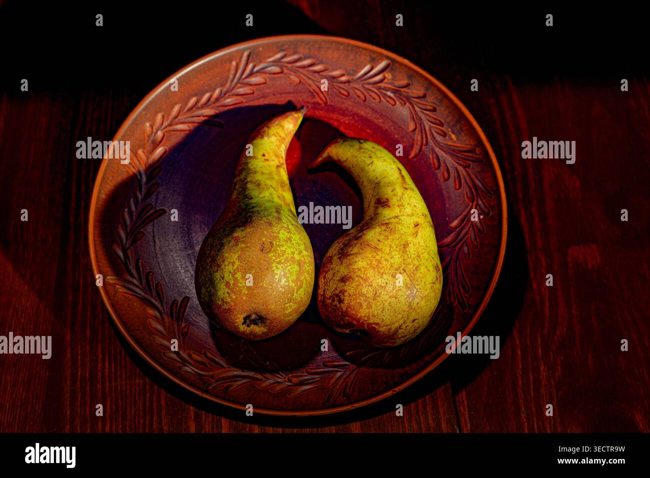 Still life with pears arranged in a ceramic plate Stock Photo