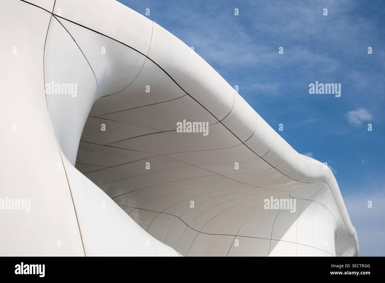 Abstract white curved architecture with smooth geometric patterns and blue sky Stock Photo
