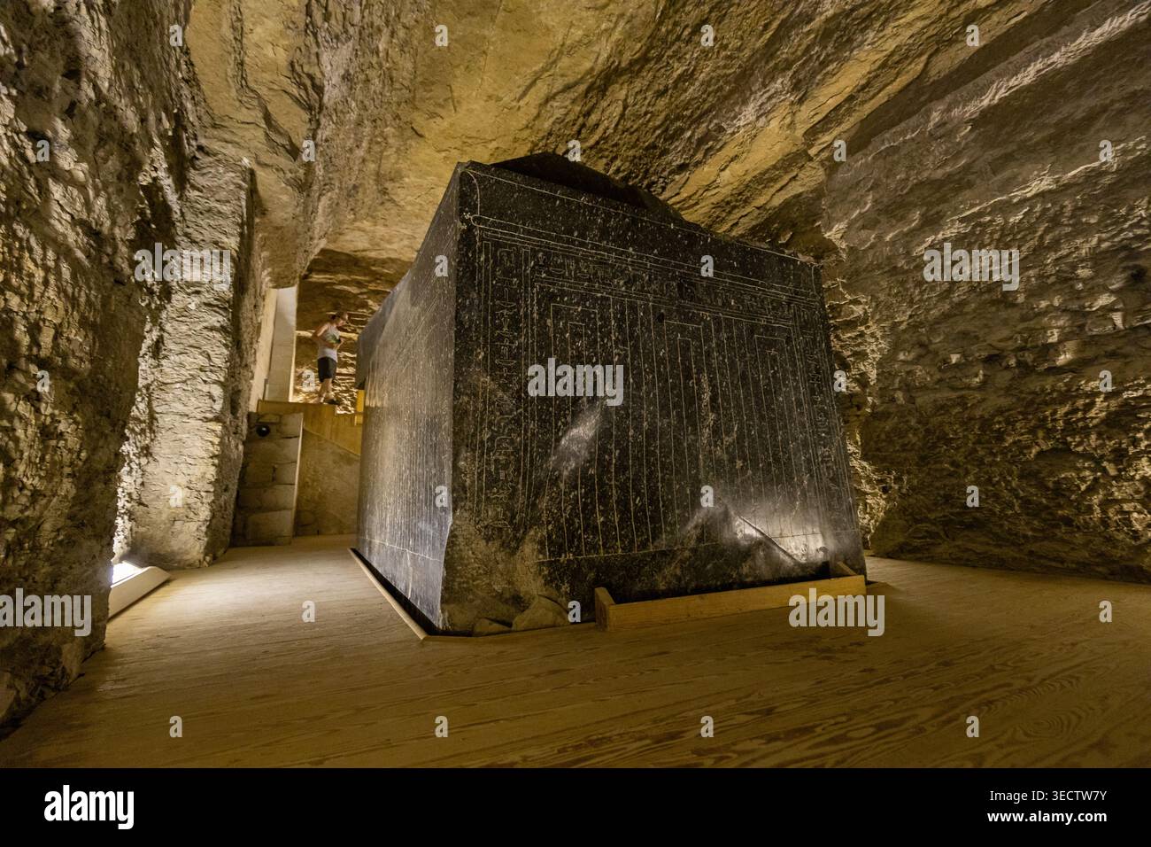 A colossal black granite sarcophagus covered in hieroglyphic ...