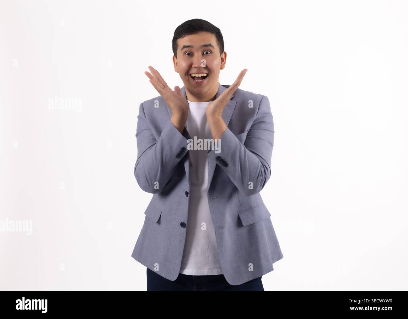 Young man in a blue jacket clapping his hands and smiling Stock Photo