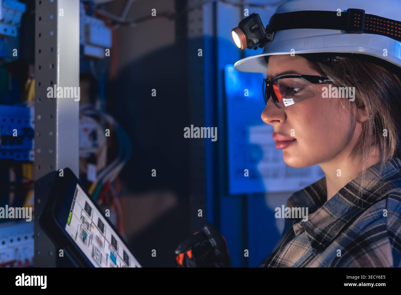 Electrical engineer analyzing power system diagram on tablet. Technical inspection. Stock Photo
