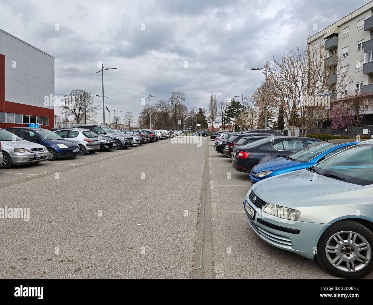 Urban Parking Lot Under Cloudy Spring Sky Stock Photo