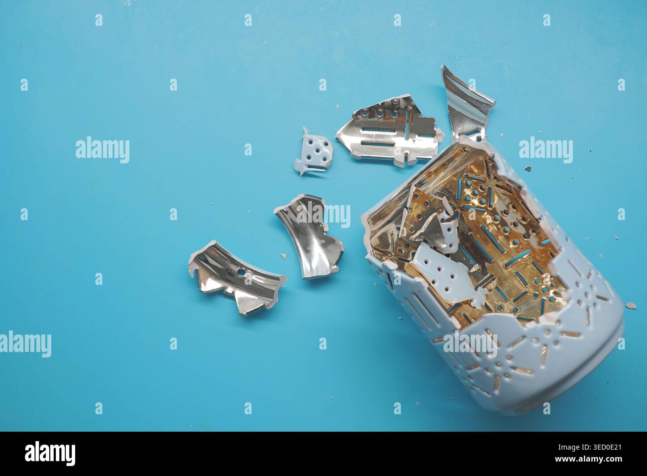Broken jar with metal pieces on blue background Stock Photo