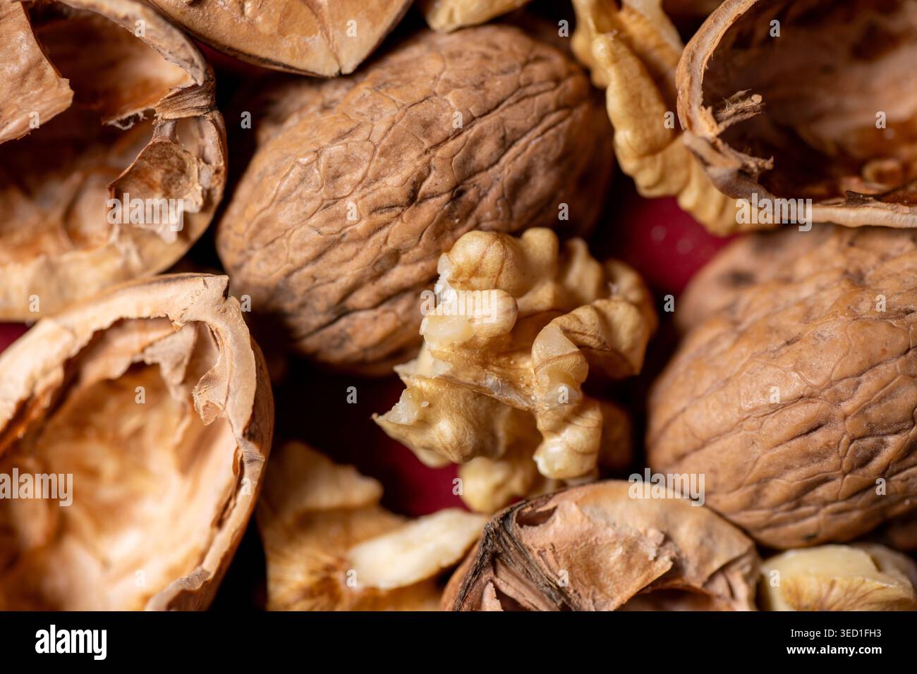 Cracked walnuts and shells on a red background Stock Photo