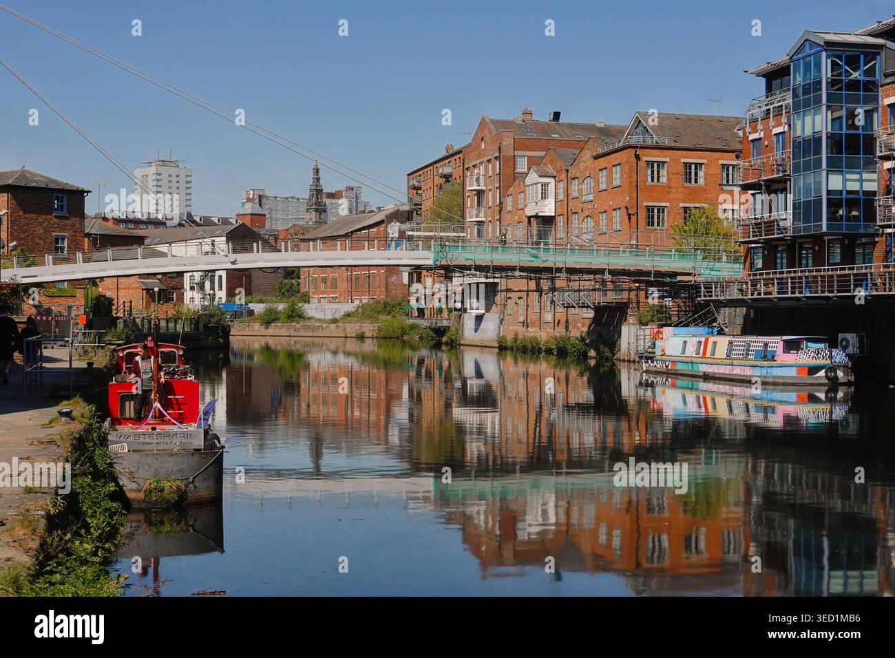 Modern waterfront apartments and a canal boat reflected in the River ...