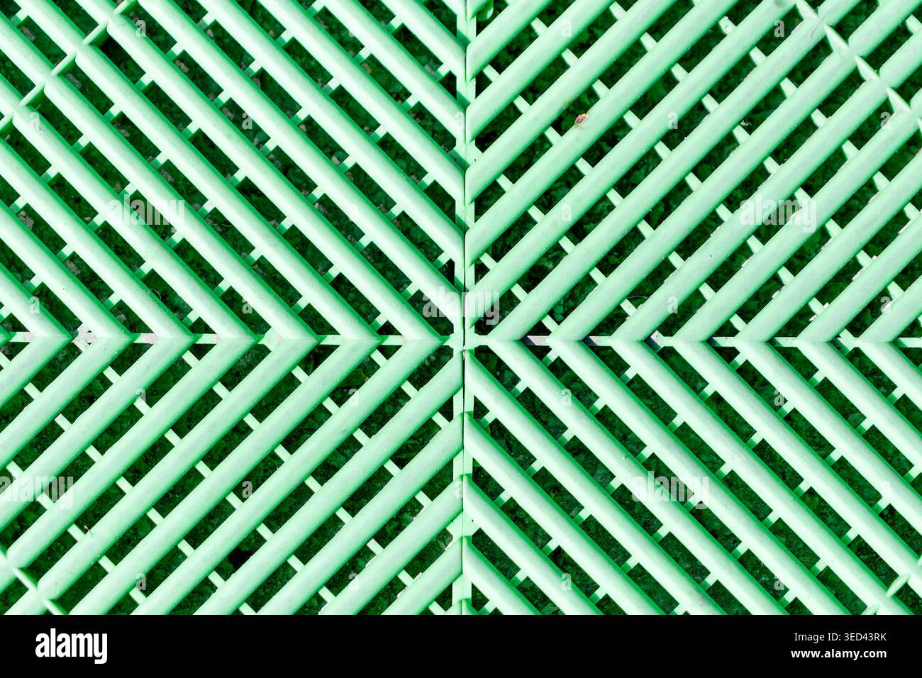 Green plastic flooring creating a vibrant abstract pattern with diagonal lines Stock Photo