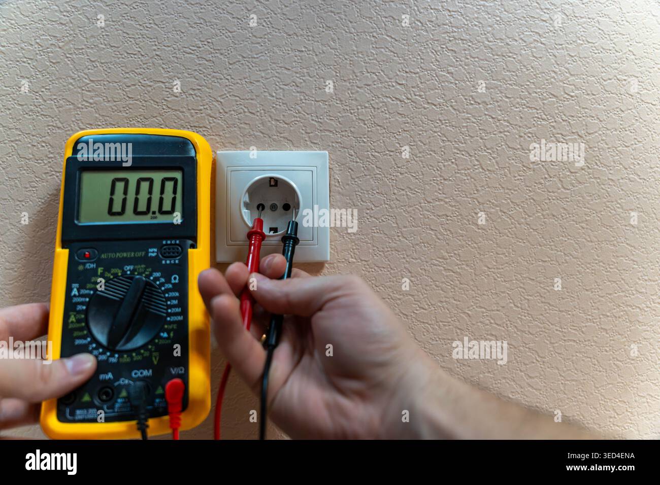 Hand Measuring Socket Voltage With Multimeter, Technician Diagnosing Live Circuit At Wall Outlet, Probe Tips Contacting Terminals, Digital Display Stock Photo