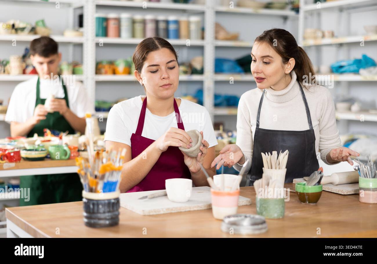 Two young women making pottery in workshop Stock Photo