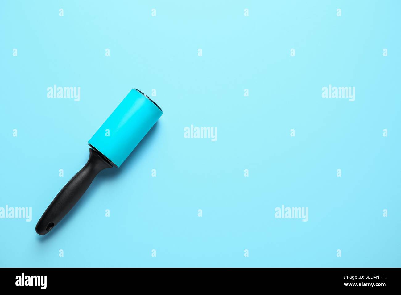 Lint roller on blue background Stock Photo