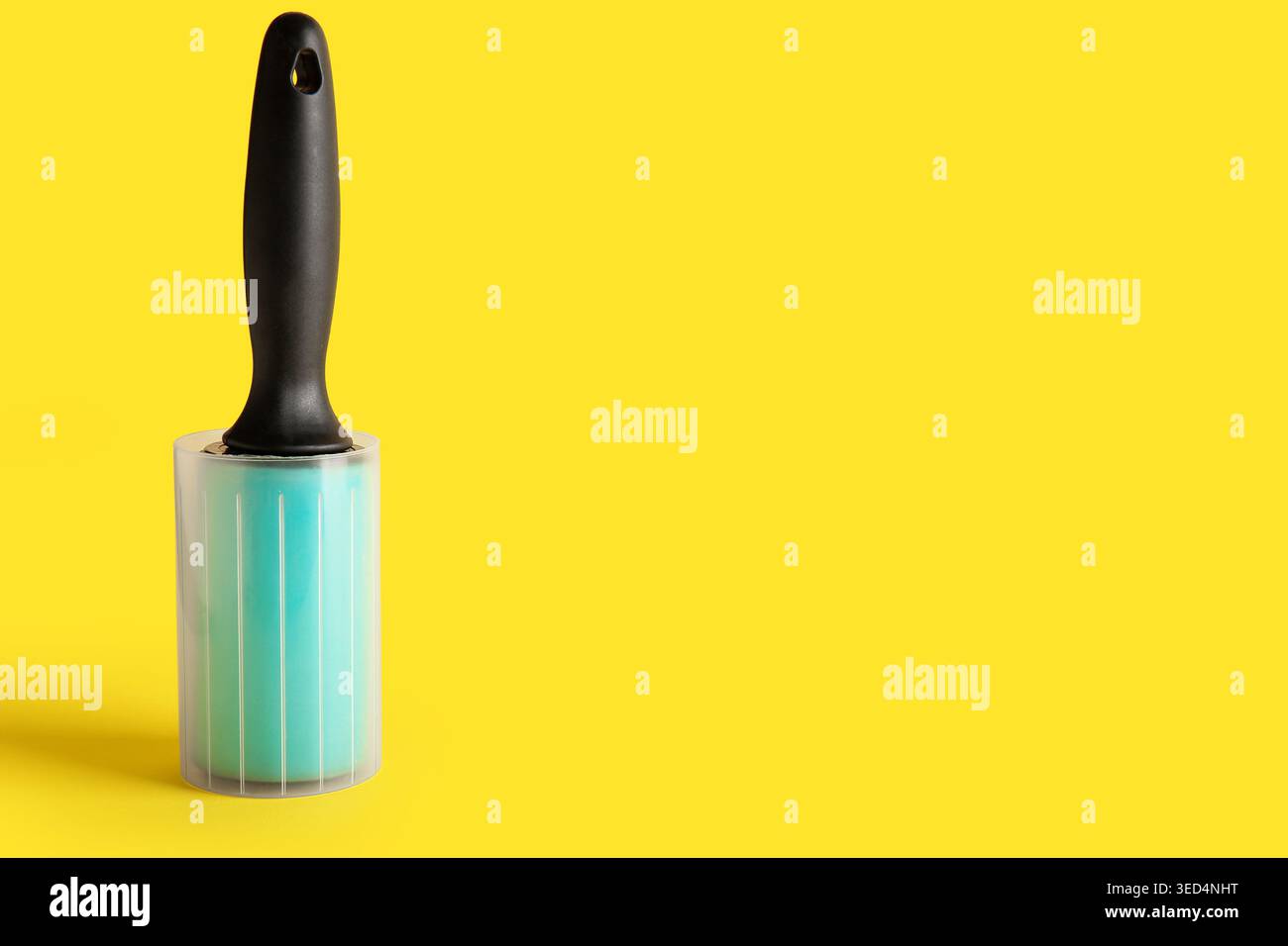 Lint roller on yellow background Stock Photo