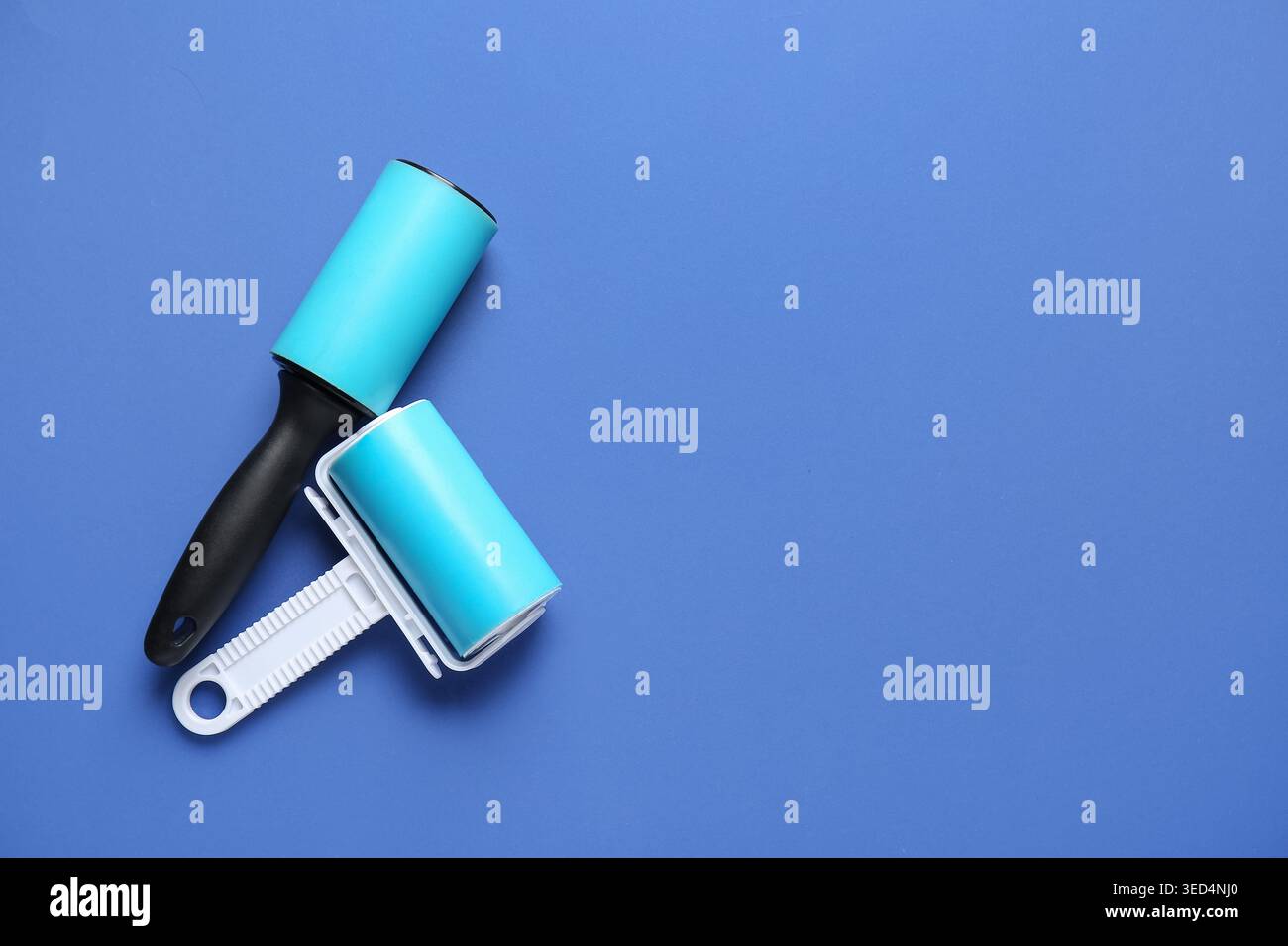 Different lint rollers on blue background Stock Photo