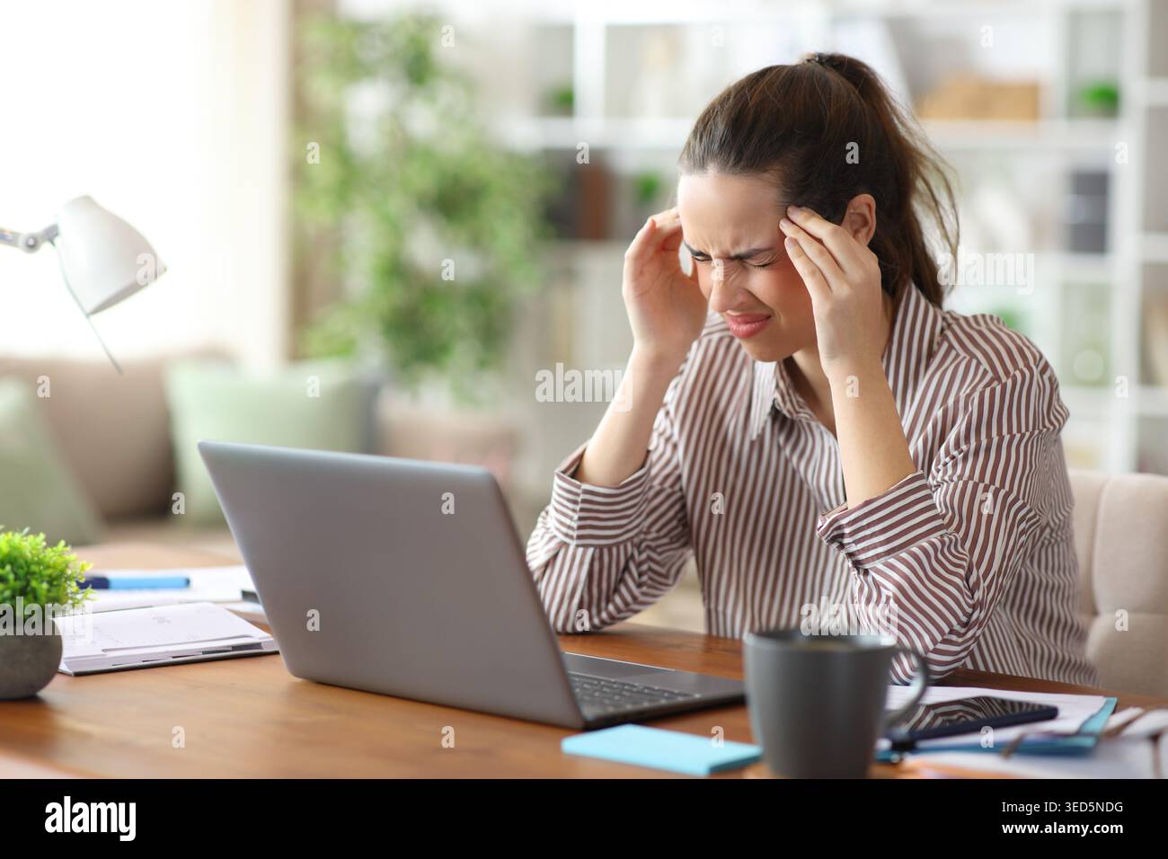 Self employed suffering hard migraine working at home Stock Photo