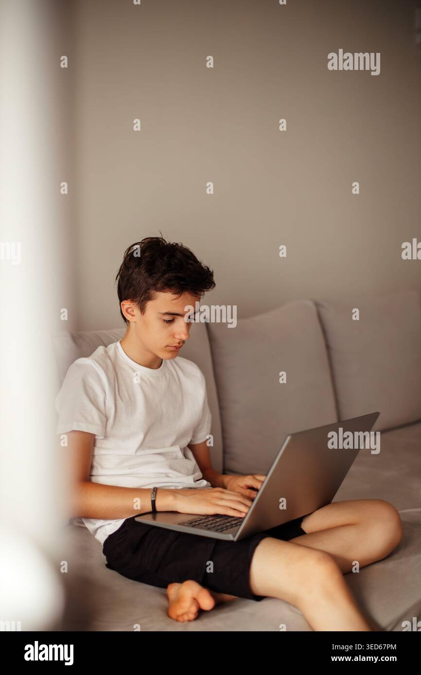 Concentrated teenager working on computer from home Stock Photo
