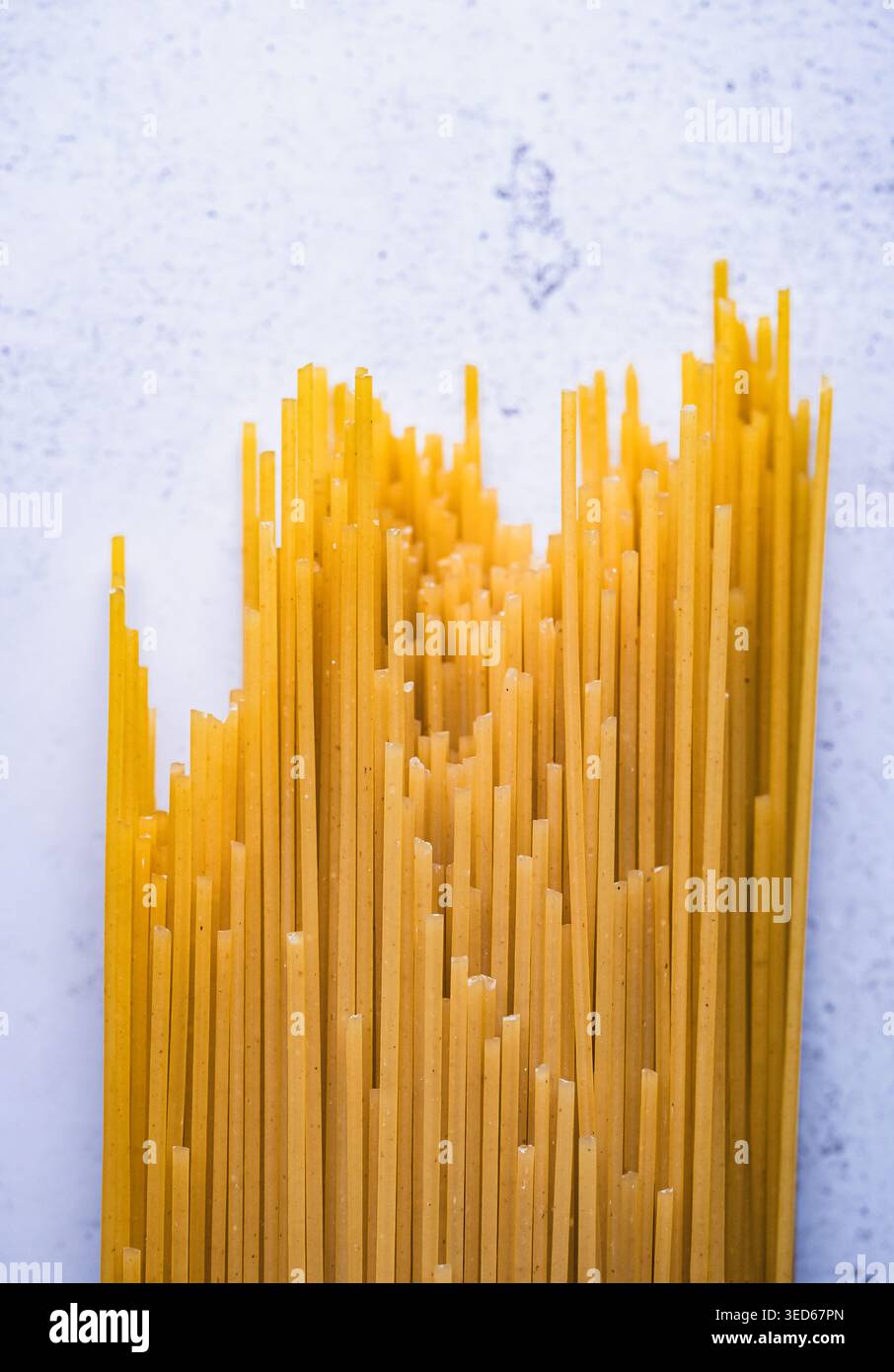 Close up of dry uncooked spaghetti noodles on stone counter. Stock Photo