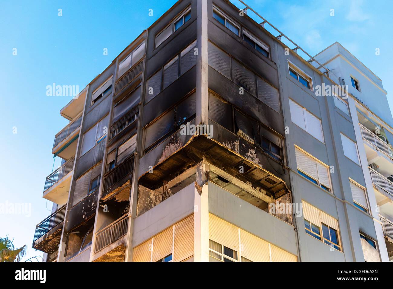 Fire damaged apartment building with blackened facade and broken ...