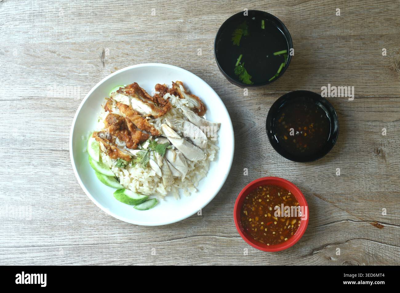 steamed rice topping chop crispy fried and boiled chicken on plate with chili sauce couple soup Stock Photo