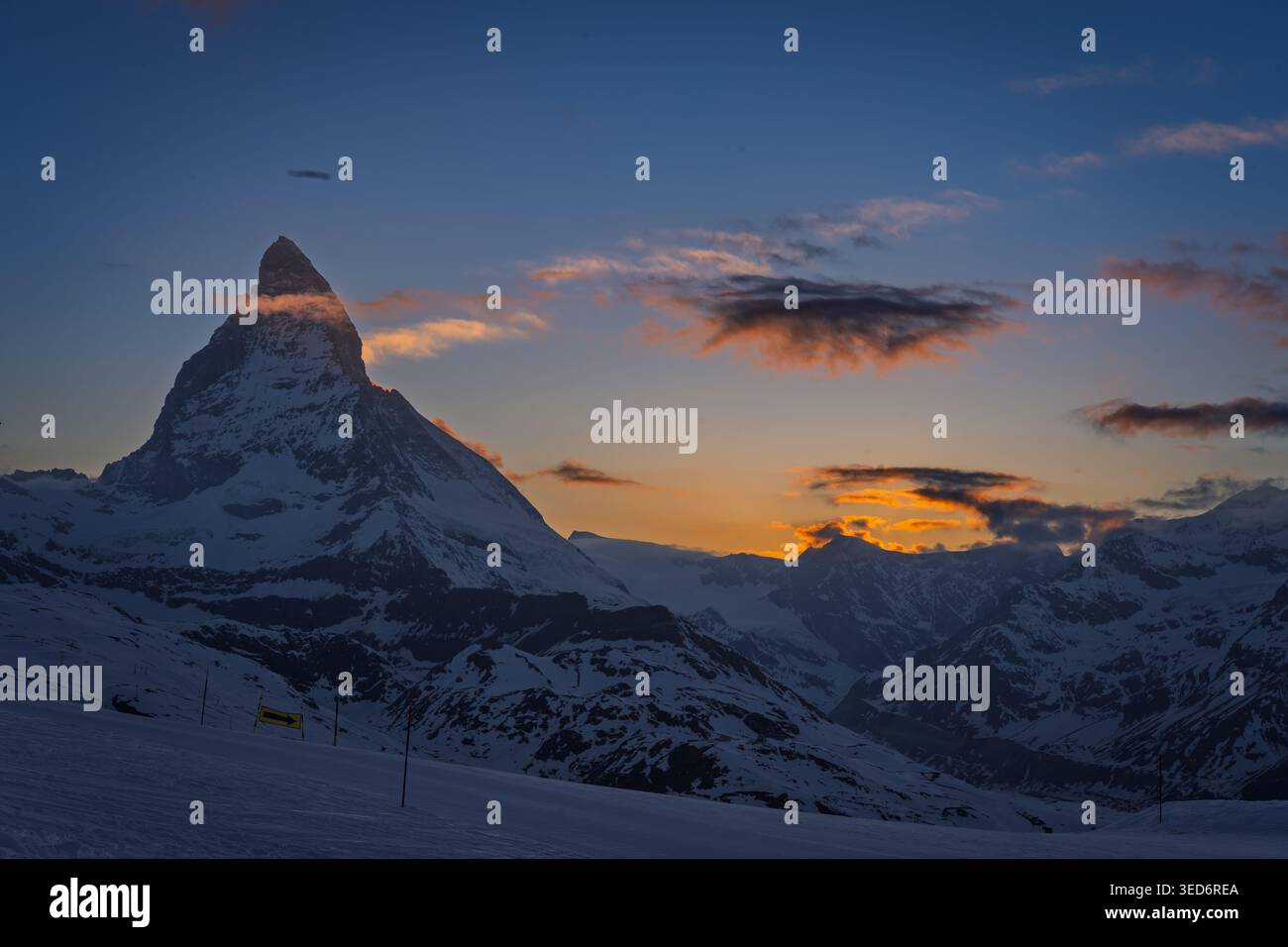 The iconic Matterhorn dominates the snowy landscape, illuminated by the ...