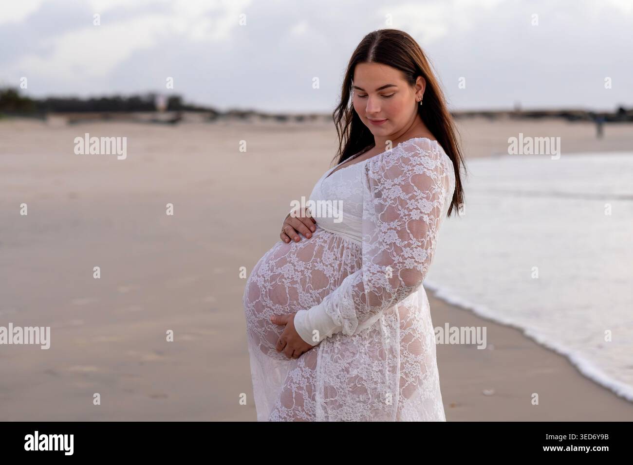 Pregnant woman standing on the beach at sunrise during a maternity  photoshoot on the Gold Coast, Queensland, Australia Stock Photo - Alamy