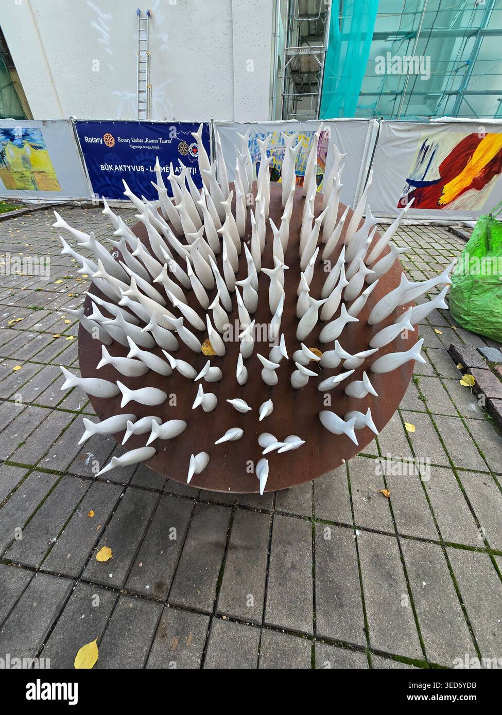 Contemporary public sculpture with white spike forms on a rust metal base in a pedestrian square in Kaunas, Lithuania - Smartphone Captured Stock Image