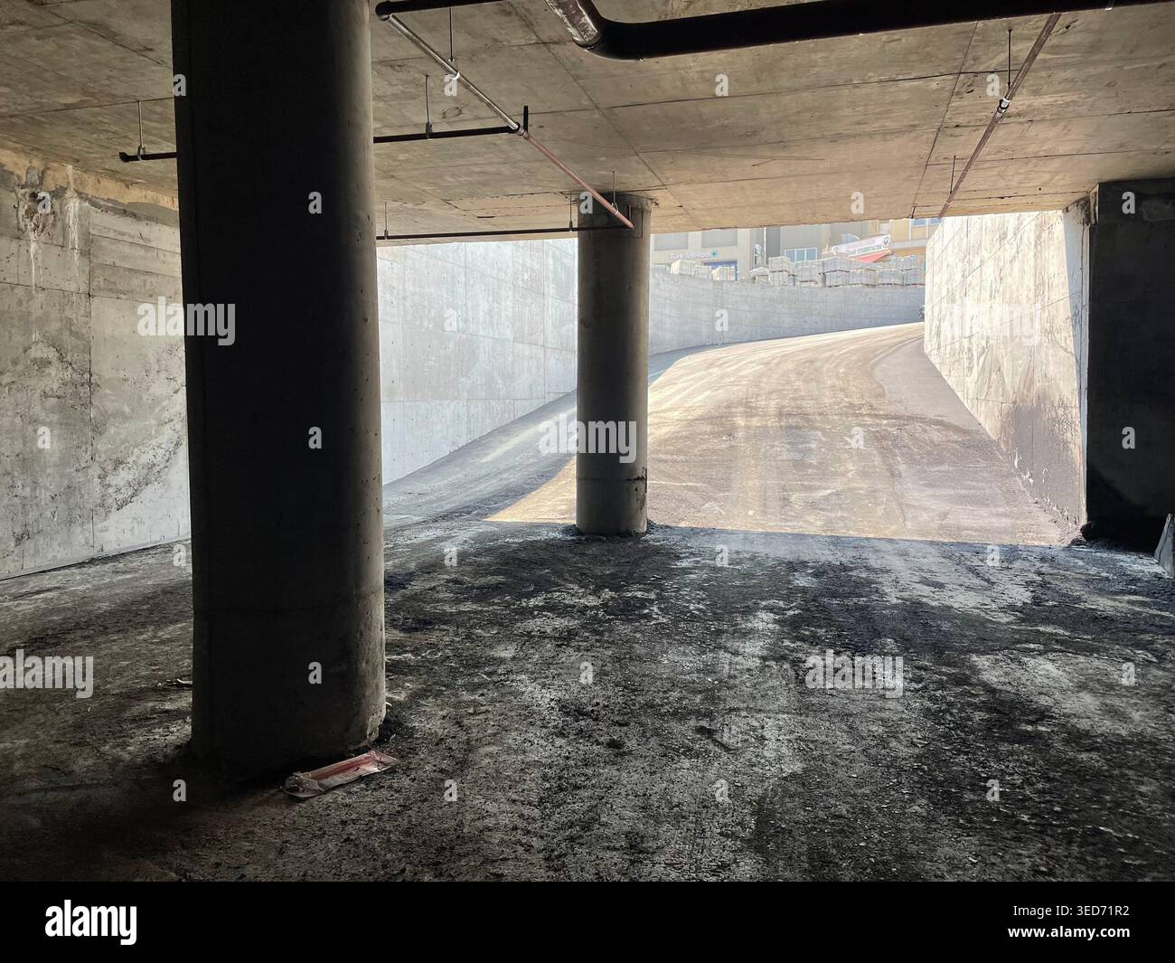 Concrete ramp exit from underground parking with pillars and daylight ...