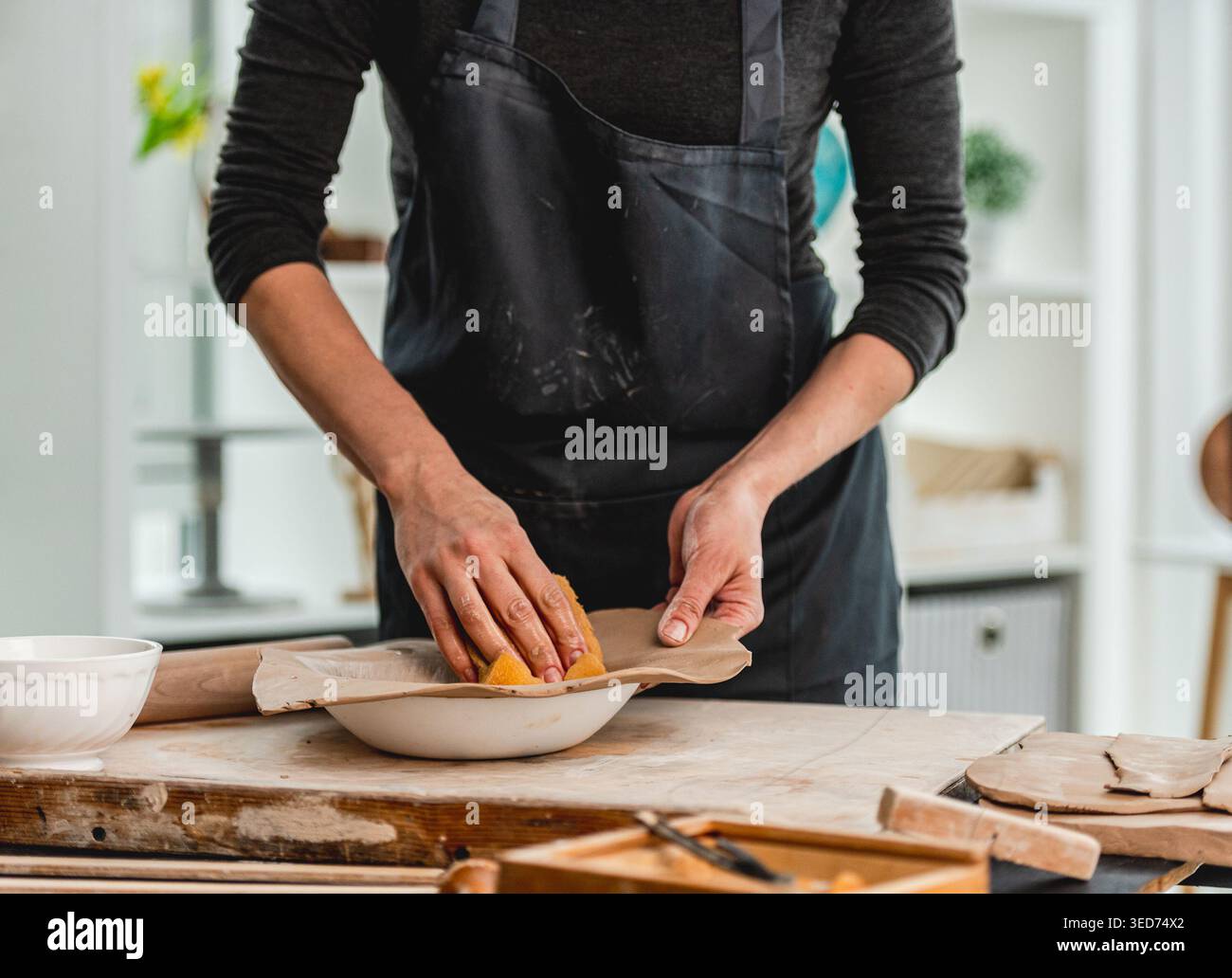 Close-Up Of Woman's Hands Making Clay Plate In Ceramics Workshop Stock Photo