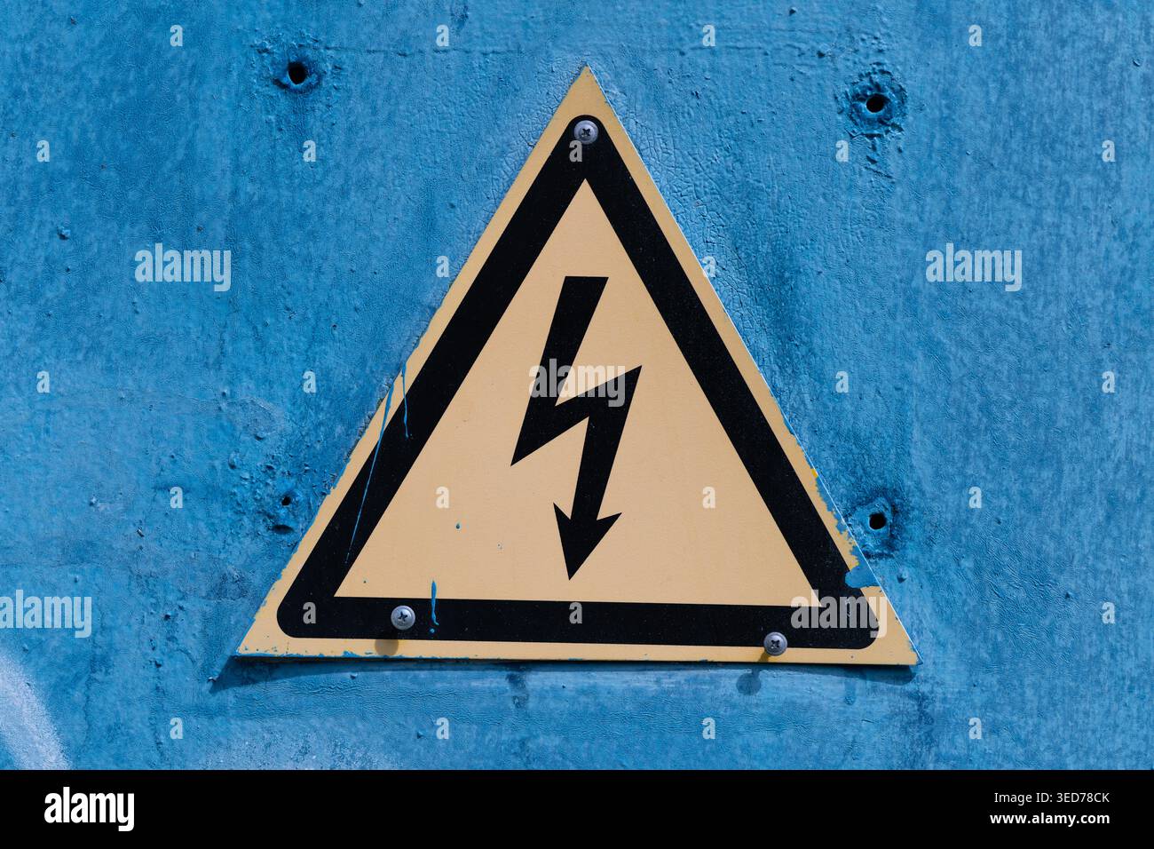 Riveting Sign Weathered blue metal warning sign depicting triangular highvoltage ...