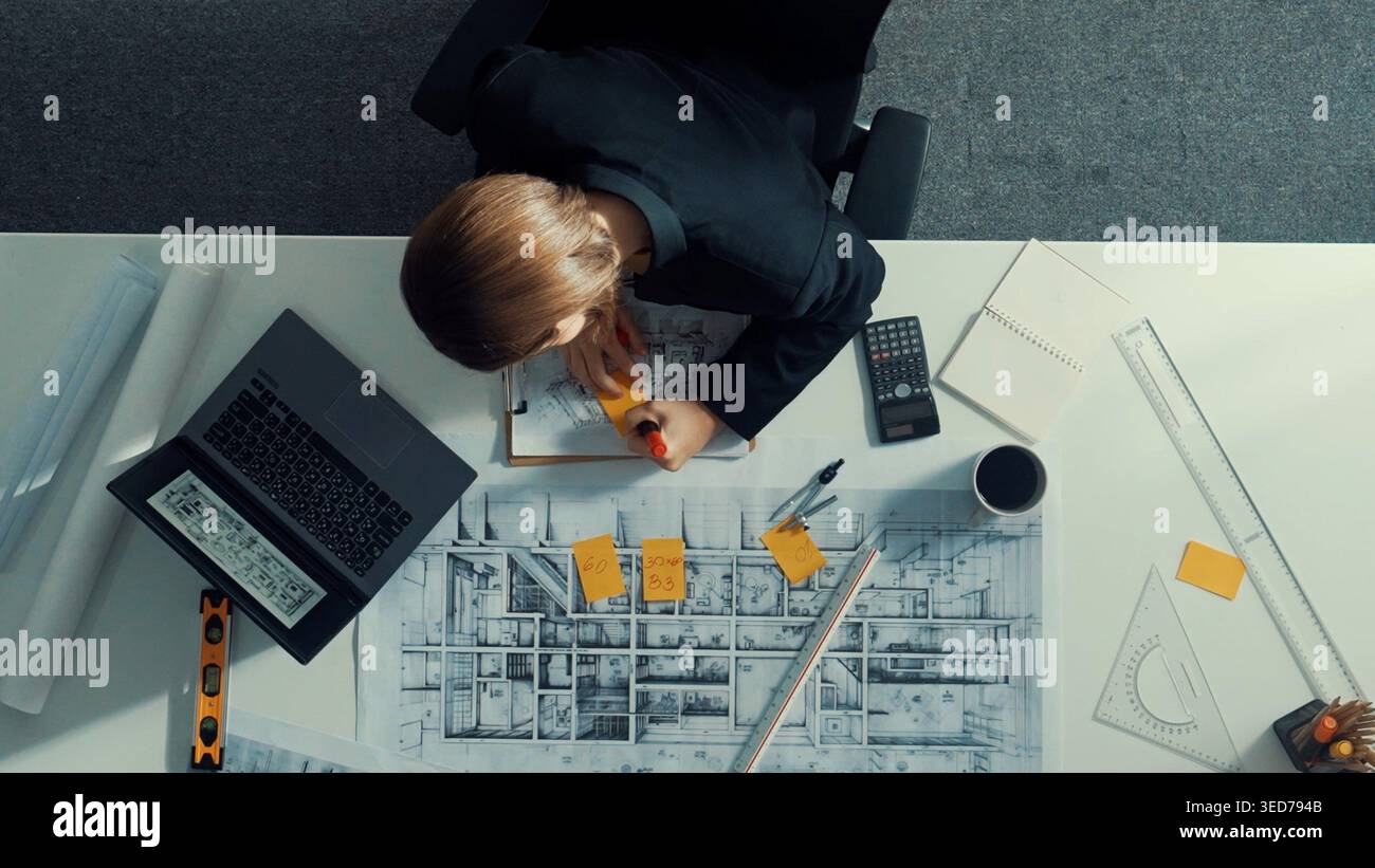 Architect engineer working while working on laptop with sticky notes and calculator to design building construction. Smart manager working and using Stock Photo