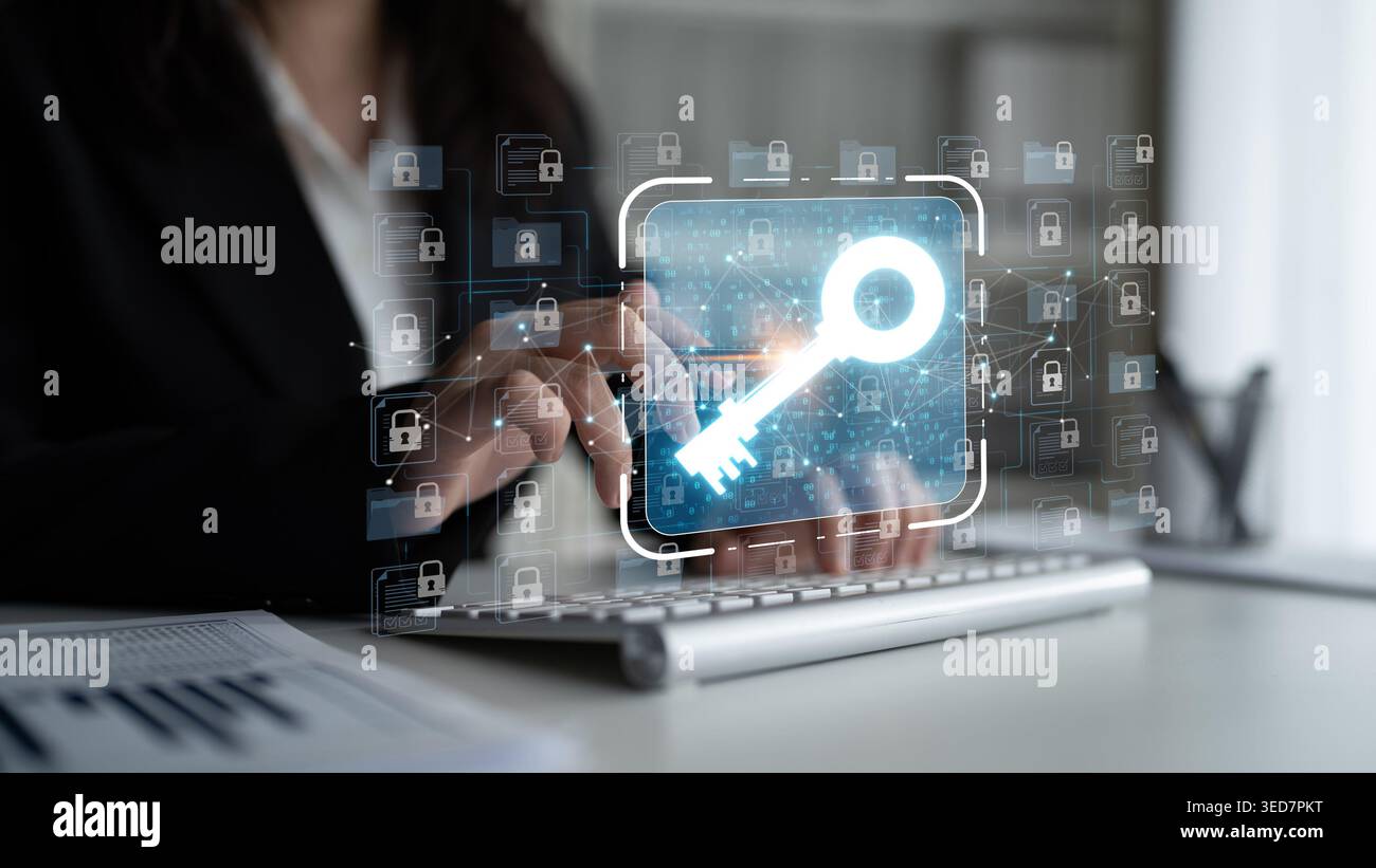 Business professional using digital technology for cybersecurity with virtual key symbol overlay on computer screen representing encryption and data Stock Photo