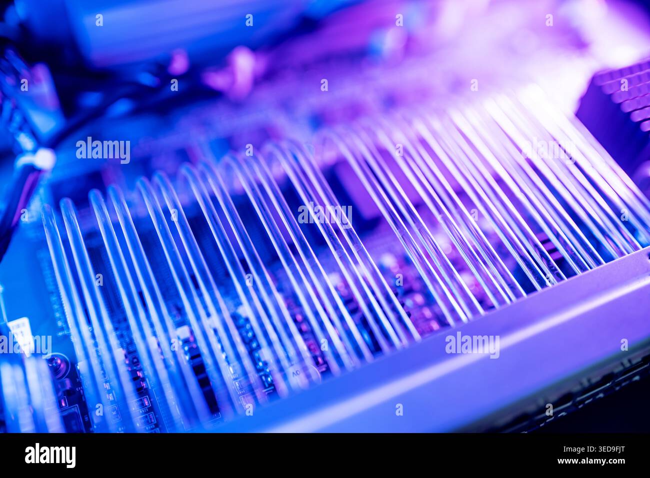 Close-up view of electronic circuit components illuminated with colorful lights. This abstract image highlights the intricate details of technology an Stock Photo
