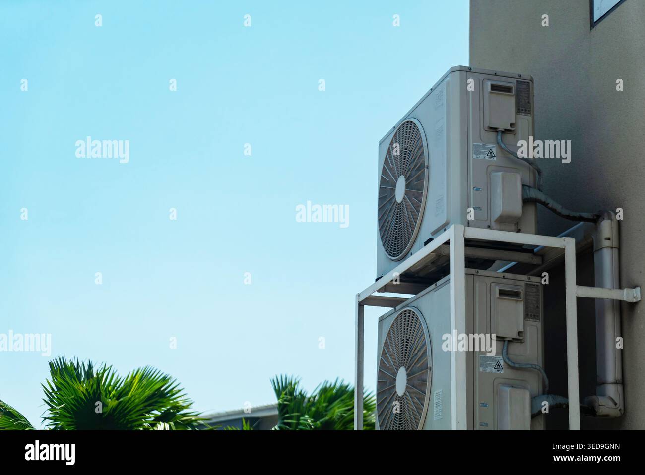 This image features two outdoor air conditioning units mounted on the ...