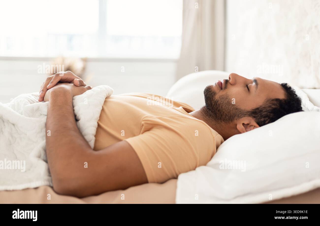 Arabic Young Man Sleeping Lying On Back Resting In Bedroom Stock Photo