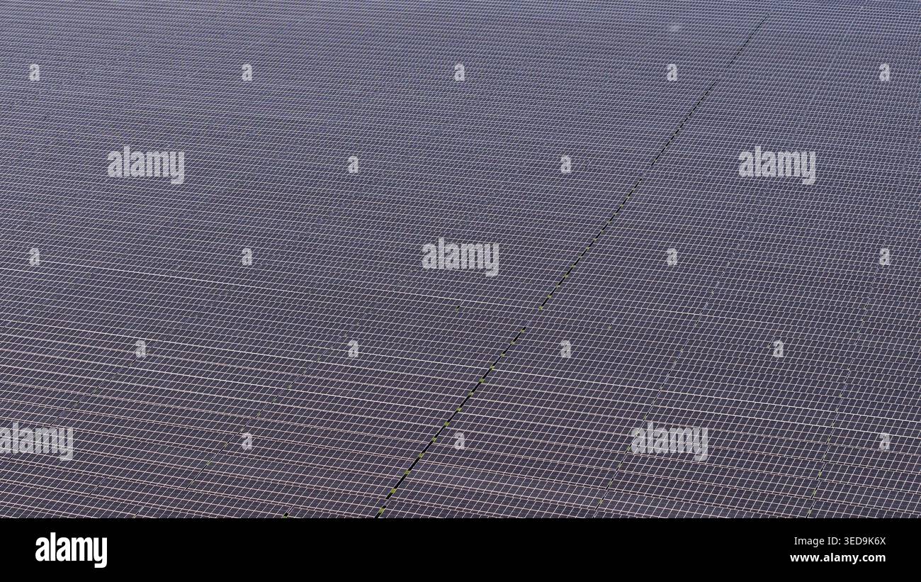An aerial perspective captures a vast array of dark blue solar panels ...