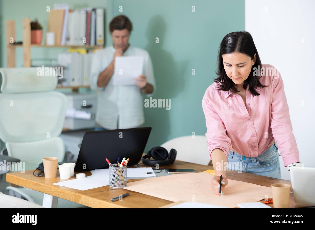 Two architects discuss a building plan in company office Stock Photo